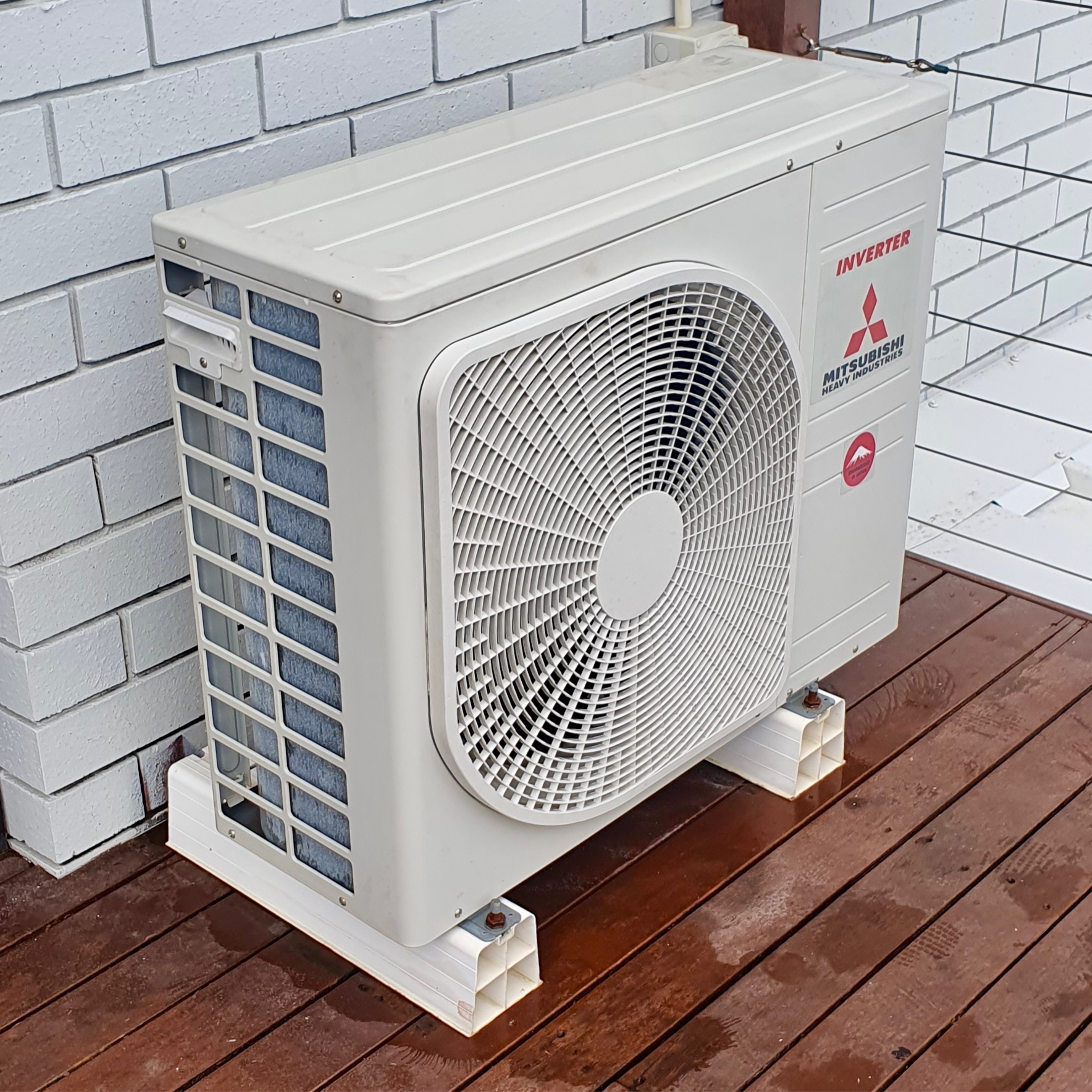 A cleaned Mitsubishi outdoor condenser unit on a Gold Coast home deck after a Natural Breeze deep clean